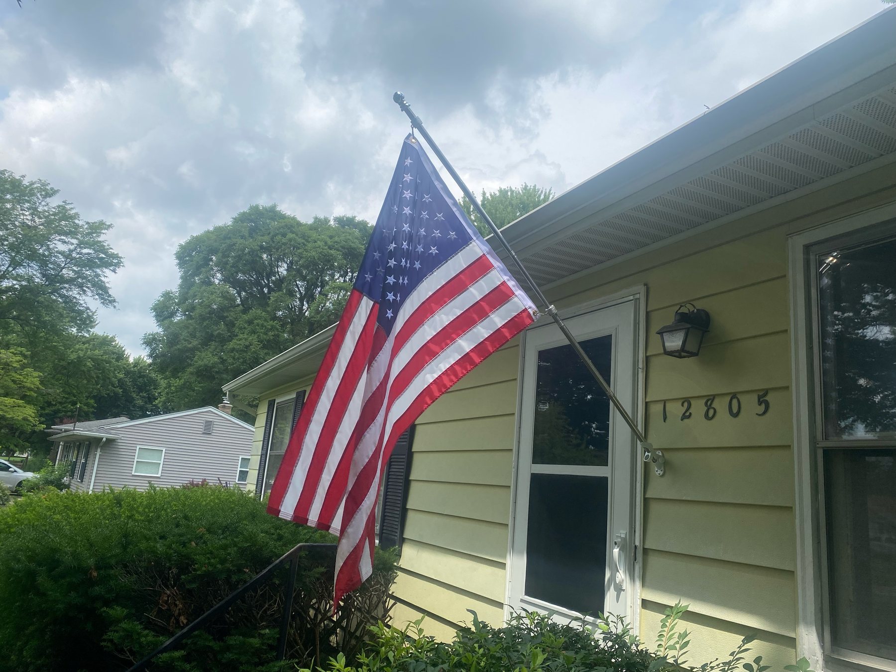 An American flag on a bracket outside a customer's ranch home, which Brandon hung after installing their door