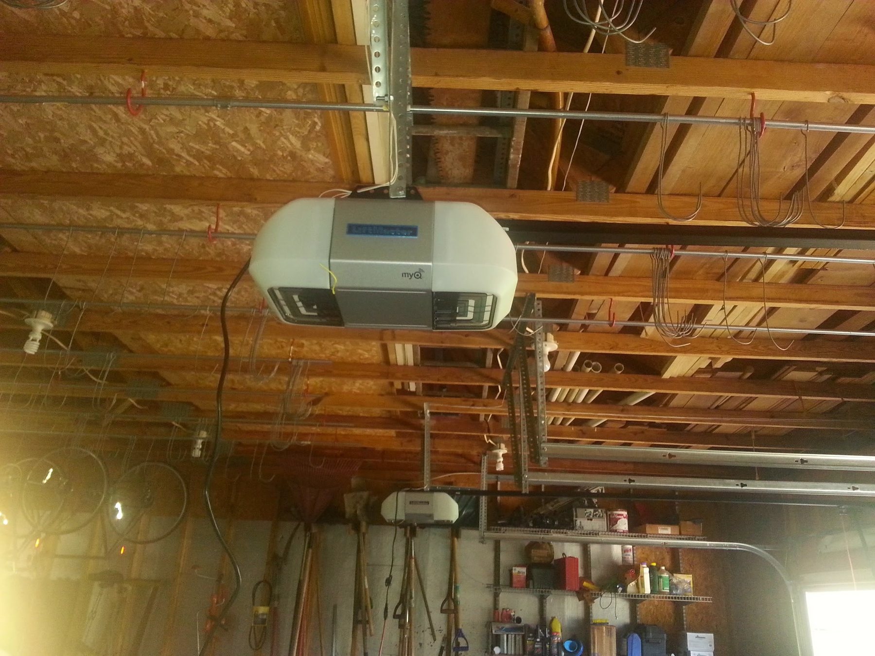 A LiftMaster garage door opener mounted to the ceiling joists of a garage