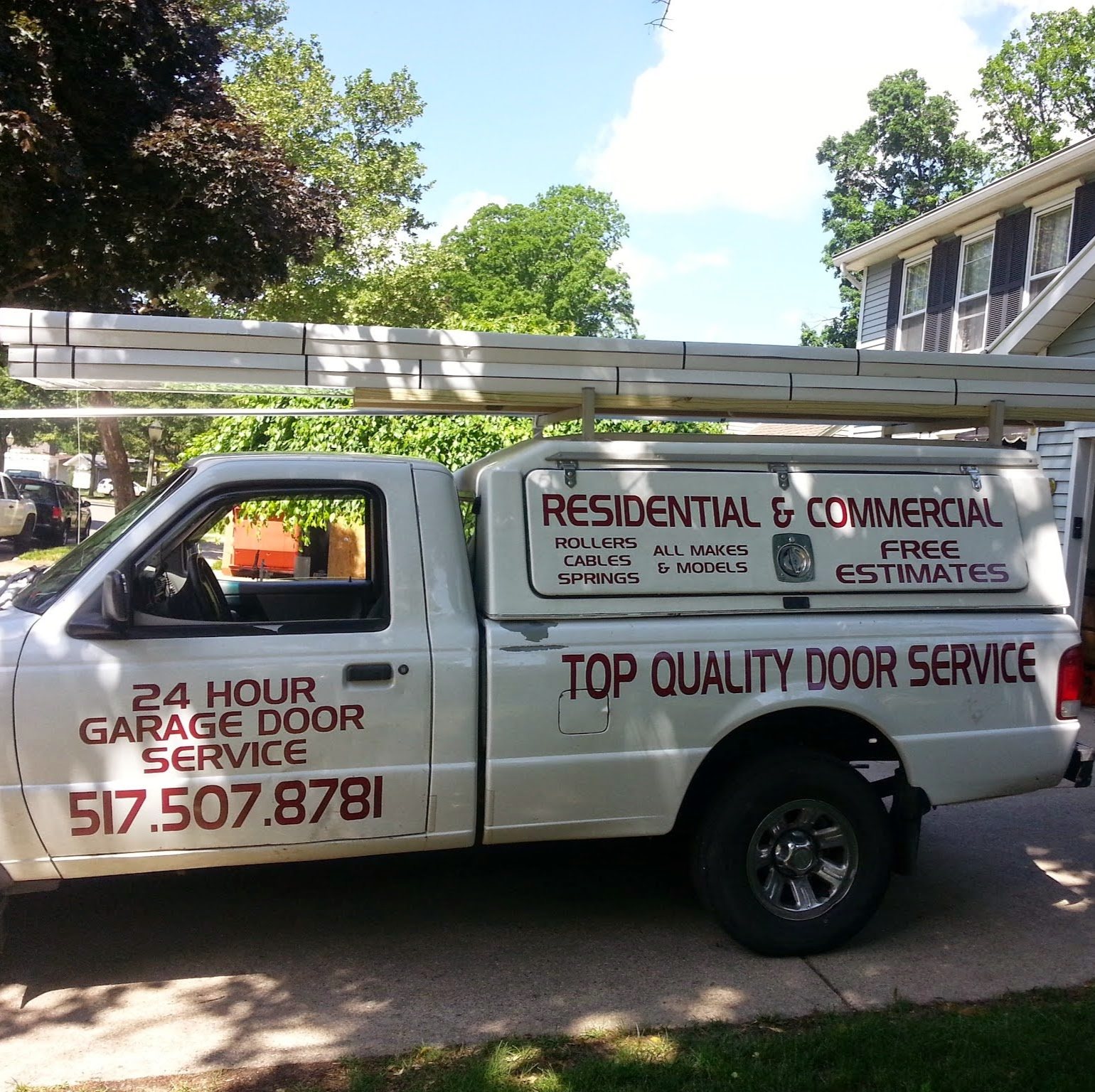 Door Service's white pickup truck lettered with the company's services: rollers, cables, springs, all makes and models, free estimates